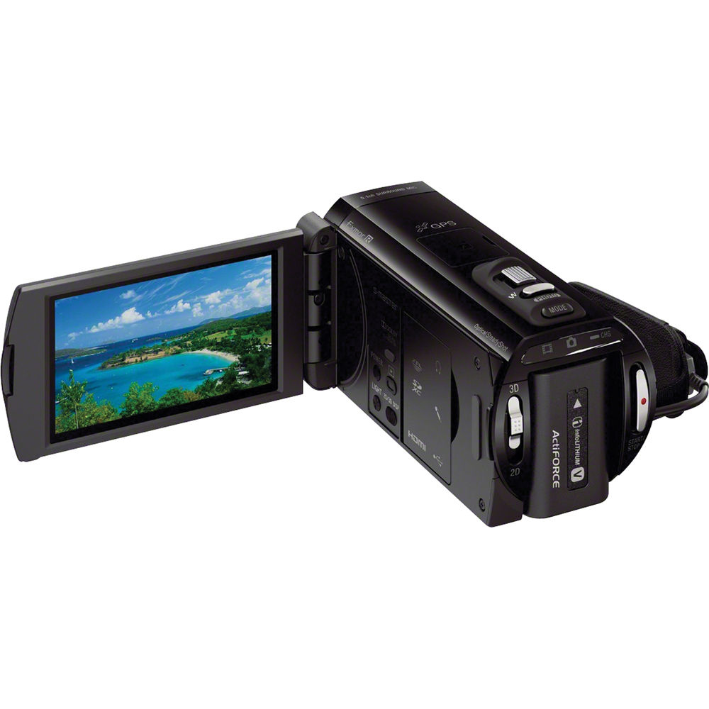 Videocámara Sony Handycam negra con pantalla LCD abierta mostrando paisaje tropical y lente frontal.
