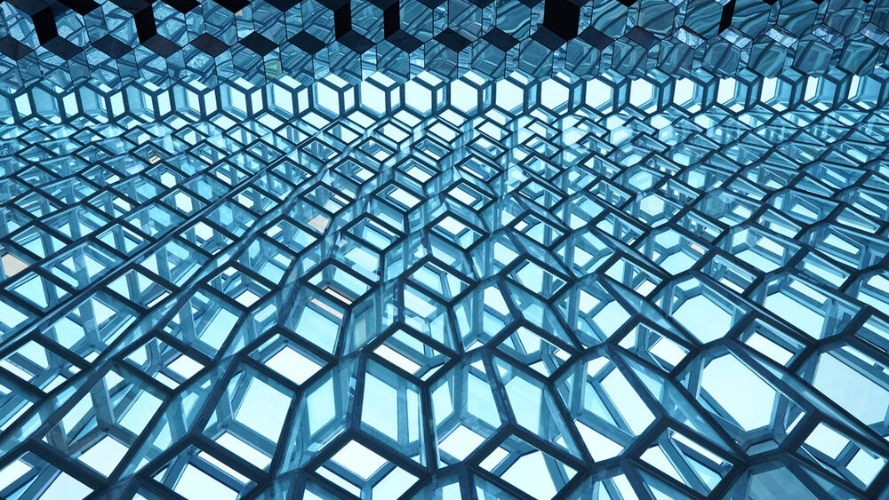 Estructura hexagonal de vidrio azul y negro, vista desde abajo.