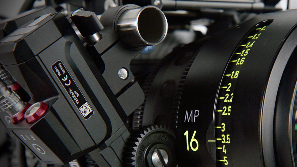 Unidad de motor ARRI cforce Mini negra, detalle de engranajes y marcas de enfoque, usada en cine.