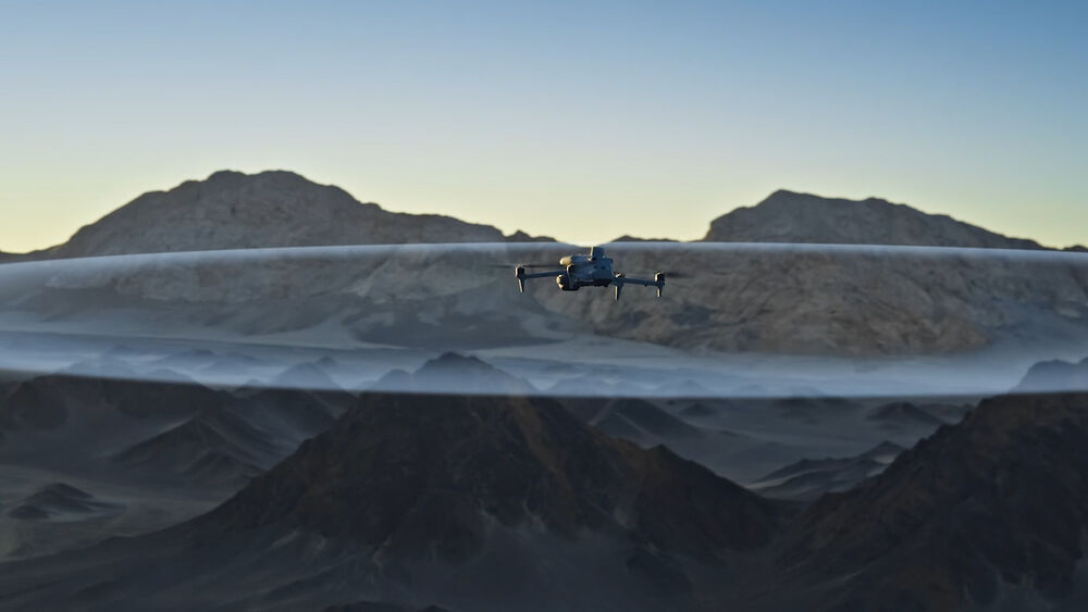 DJI Matrice 4E drone volando sobre montañas al amanecer, con efecto visual de capa translúcida.